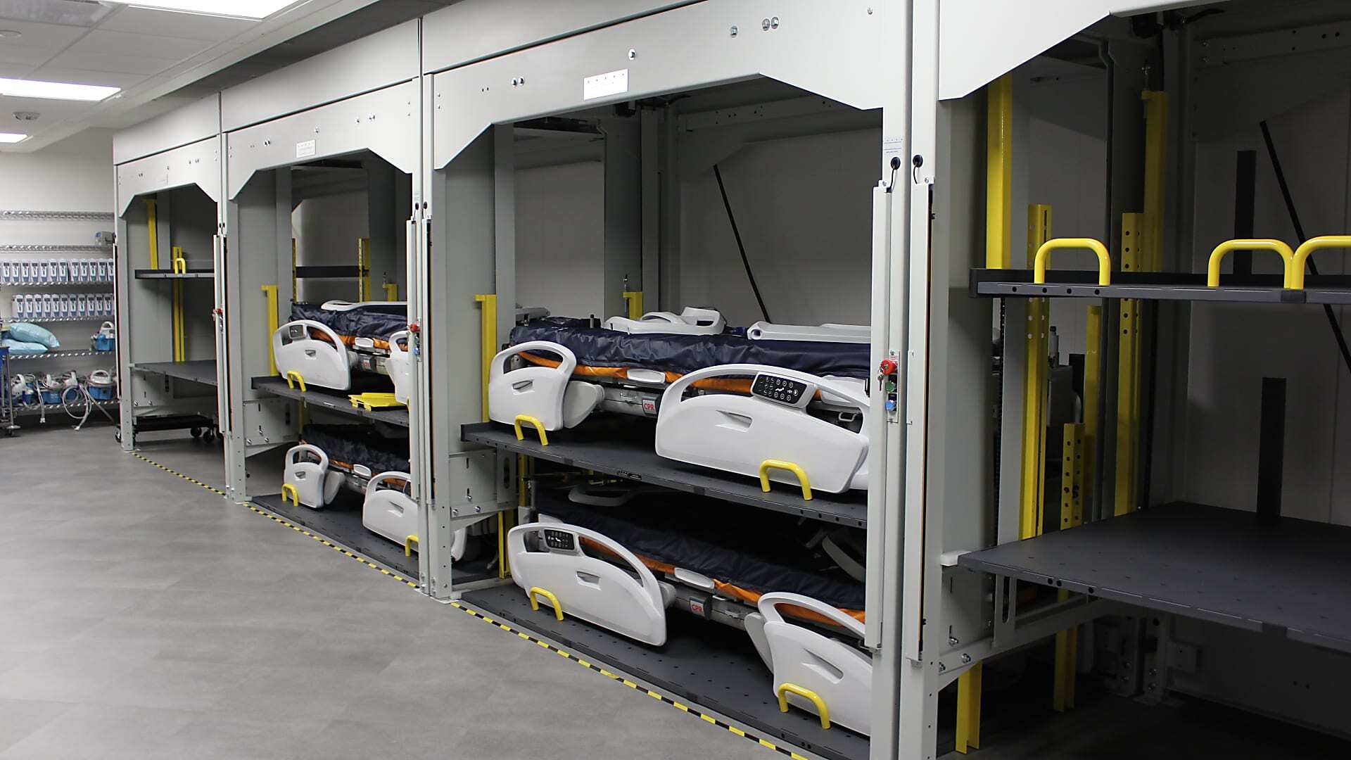 Vertical hospital bed storage system reducing floor space requirements