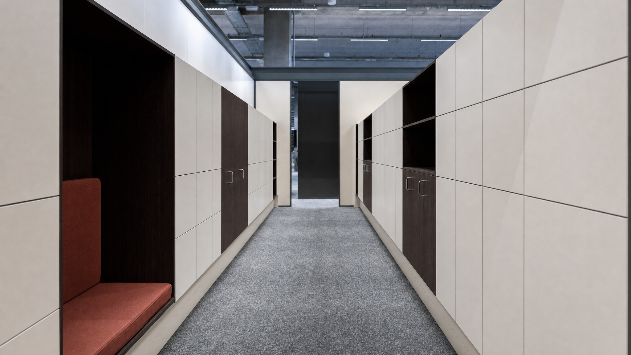 Two rows of modern beige and dark wood lockers with integrated open seating alcoves.