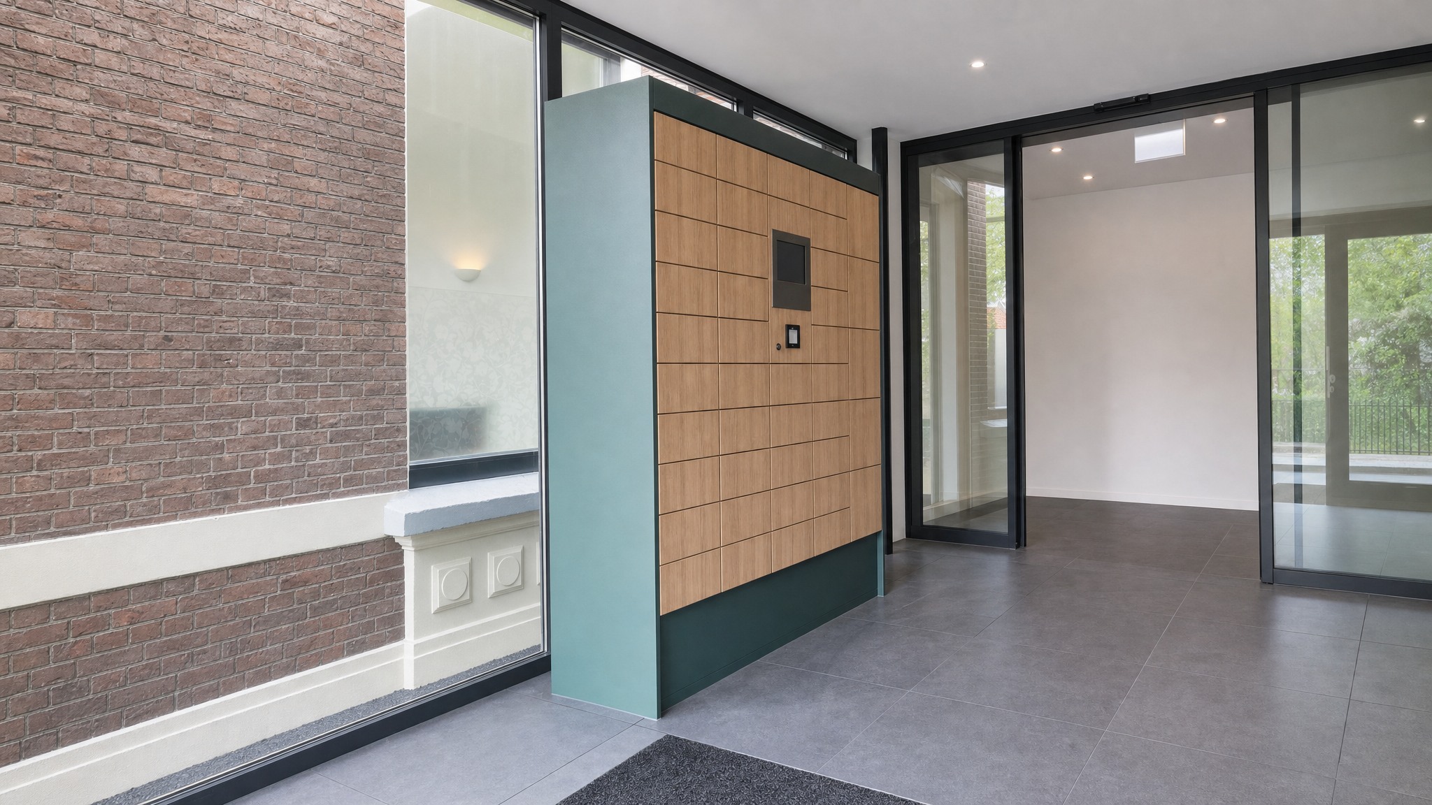 Wood finish locker wall with integrated display in a modern glass entryway.