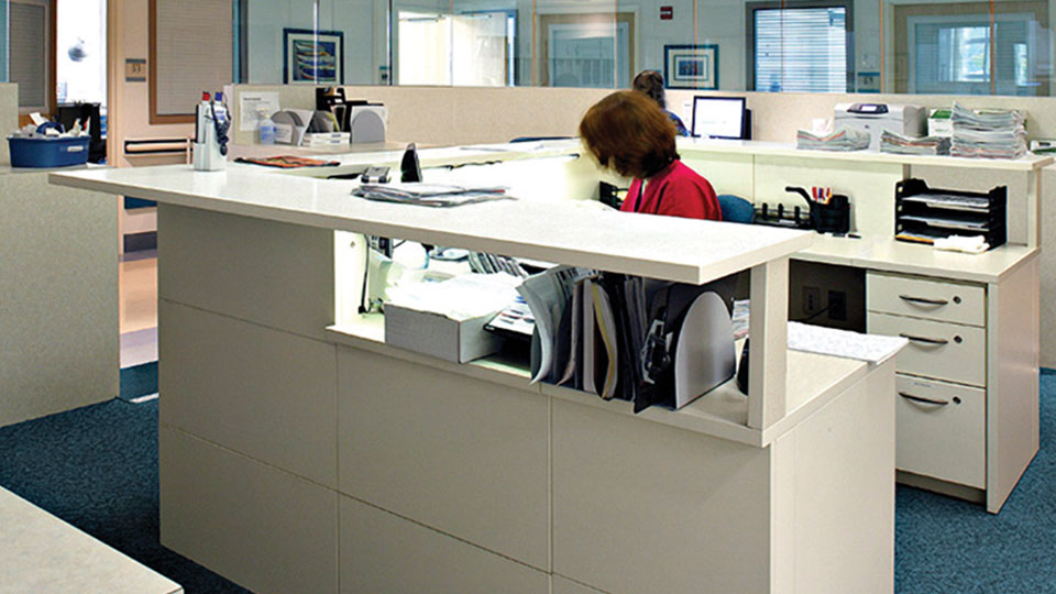 Modular command center casework with integrated workstations and transaction counter designed for efficient medical office or hospital reception areas.