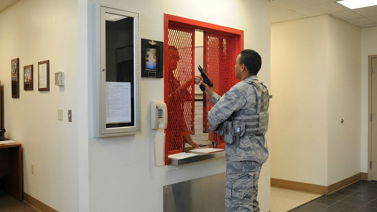 military armory access control window with service member checking equipment at secured counter